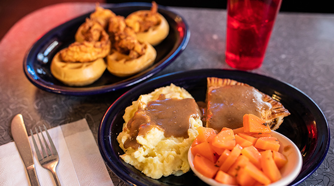 Red Arrow, a 24-hour diner in Manchester, New Hampshire, serves comfort food like the Blue Plate Specials shown here: chicken and waffles and pork pie dinner. | Photo by Jennifer Bakos