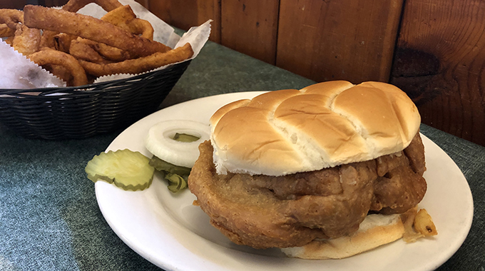 Hilltop brain sandwich served with pickles and onions 