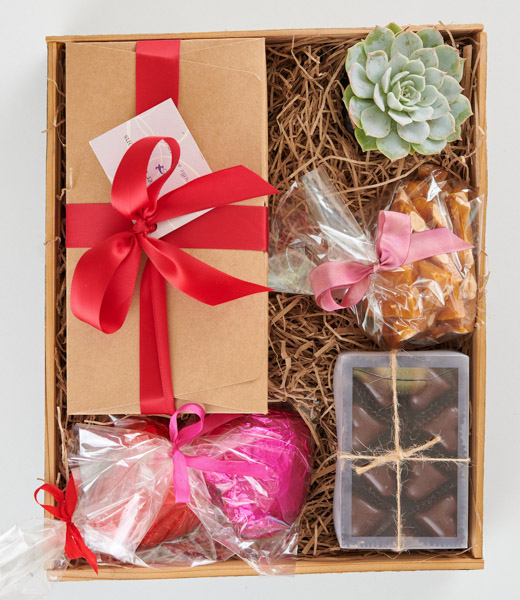 Truffles, chocolate hearts, almond brittle, and more arranged in a gift box