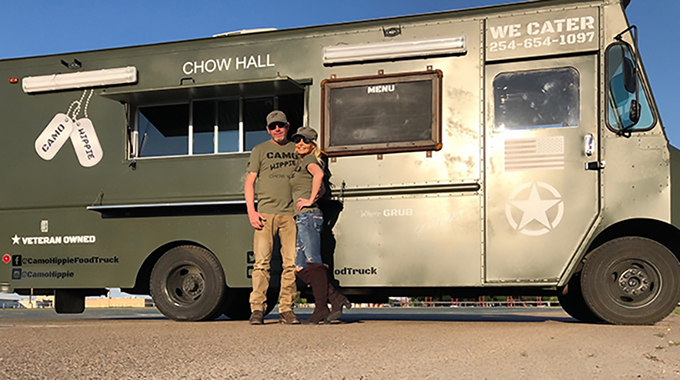 Blake and Kelli Oseen in front of Camo Hippie Chow Hall