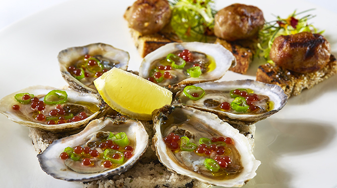 Oysters with mignonette pearls served with a slice of lemon