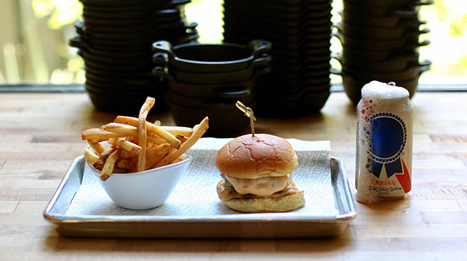 Burger, fries, and a can of Pabst Blue Ribbon at Cured