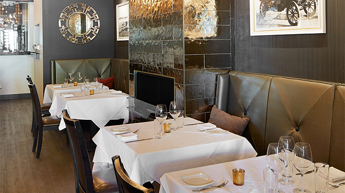 Tables near the fireplace inside Greensleeves Steakhouse