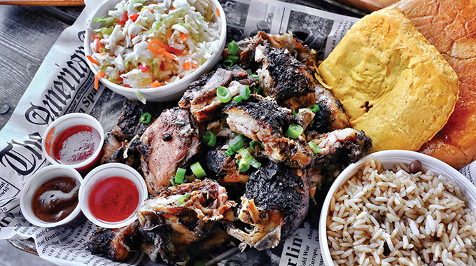 Grilled jerk chicken with Rice ‘N Peas and cabbage slaw. | Photo courtesy The Jerk Shack
