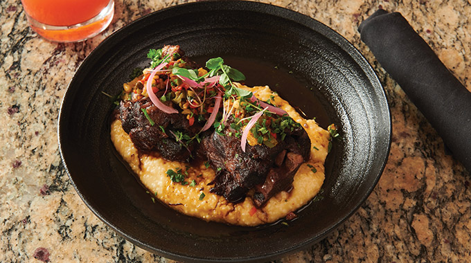 Braised oxtail with Serrano Cheddar Grits. | Photo by Kennon Evett