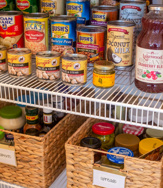 Sorted cans and jars inside a newly organized pantry