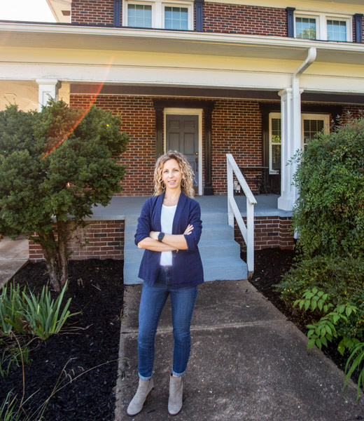 Kati Wadsworth standing in front of her home