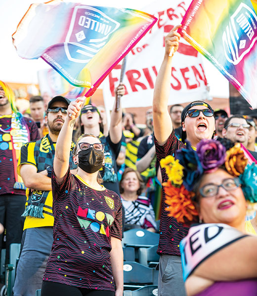 Fans waving Rainbow United flags during Pride Night