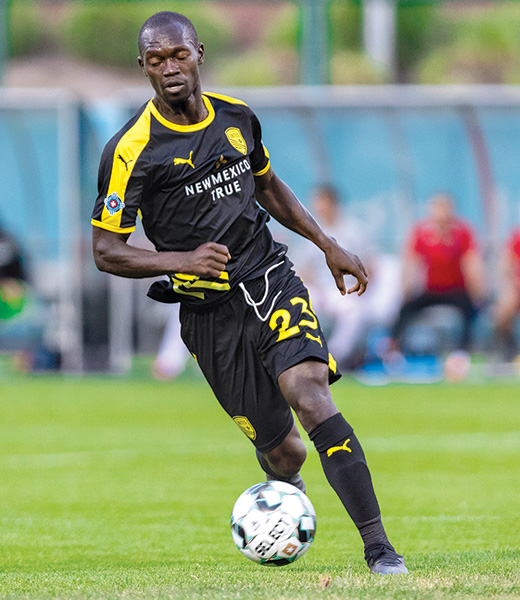 New Mexico United midfielder Mike Azira dribbles down the pitch.