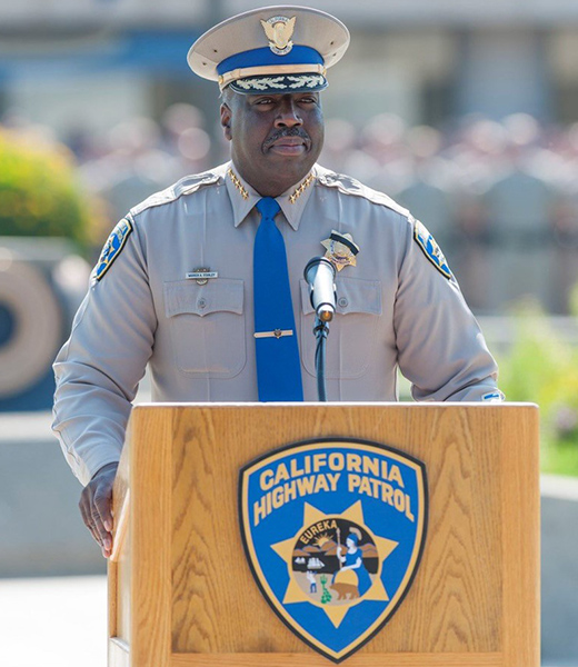 Retired California Highway Patrol Commissioner Warren Stanley standing behind a podium