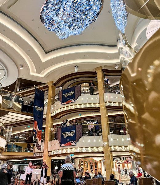 Guests watching a violin duo perform in the Discovery Princess atrium.