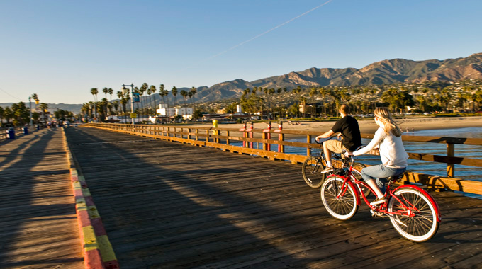 A pair of bicyclists riding through Stearns Wharf.