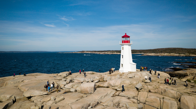 Visitors exploring the grounds surrounding a lighthouse