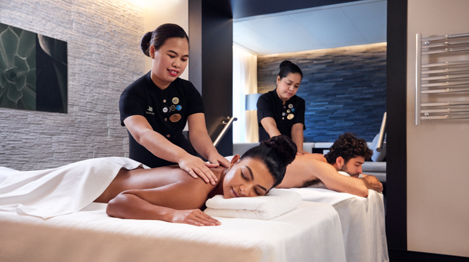 Couple receiving massages on side-by-side tables