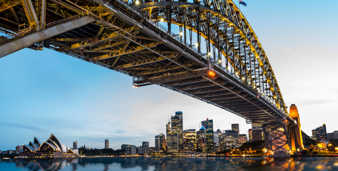 Looking up at the Sydney Harbour Bridge, with the Sydney Opera House in the distance.