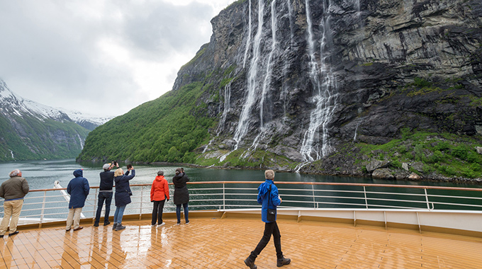 Cruisers viewing a waterfall from the deck of a Holland America cruise ship