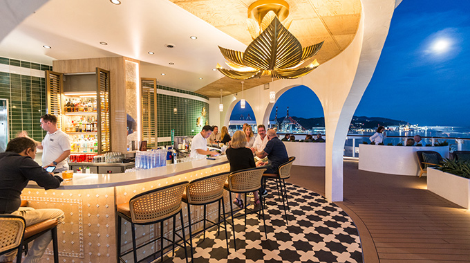 Travelers chatting over drinks at the Celebrity Cruise Sunset Bar