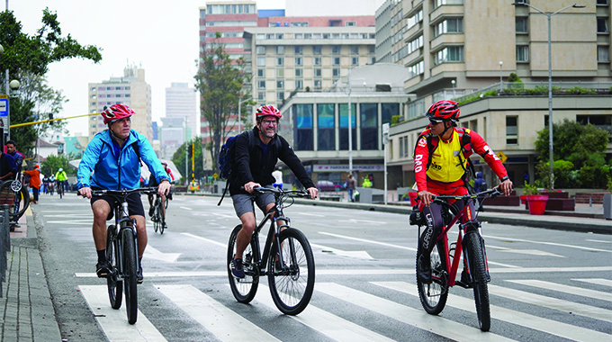 Three men riding bicycles.