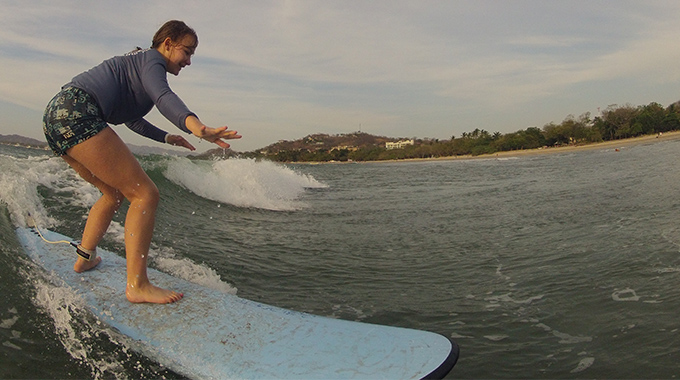Lucia Benning hops to her feet while learning to surf in Costa Rica.