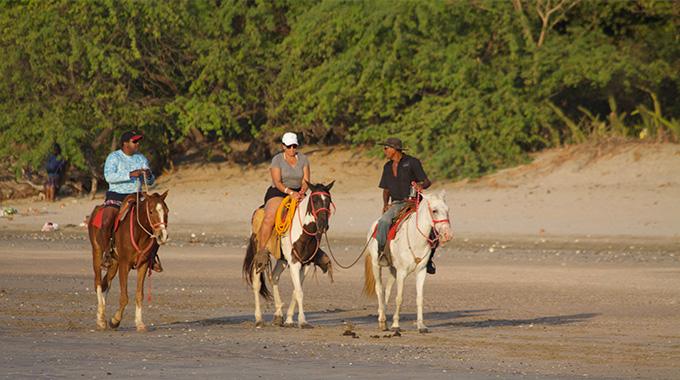 Horseback riders on the beach in Tamarindo, Costa Rica