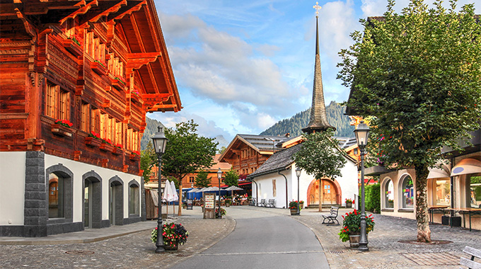 The spire of St. Nicholas Chapel stands out on the promenade of Gstaad. | Photo by Bogdan Lazar/stock.adobe.com