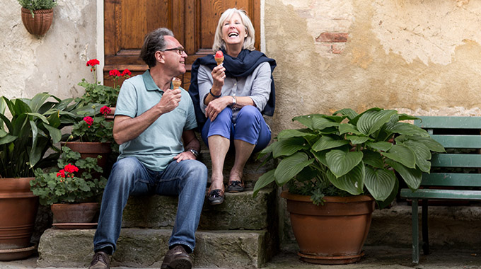 A couple eats gelato on vacation. 