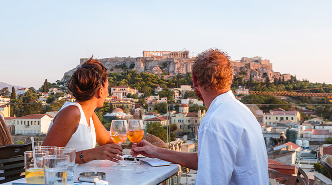 A couple enjoy a view of the Acropolis, Athens, Greece.