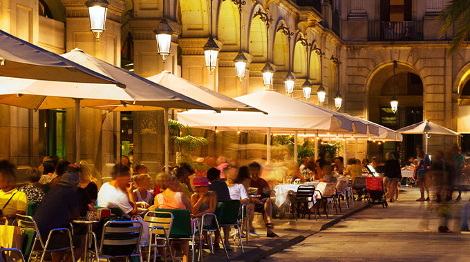 Restaurants at Plaça Reial on a summer night in Barcelona, Catalonia, Spain.