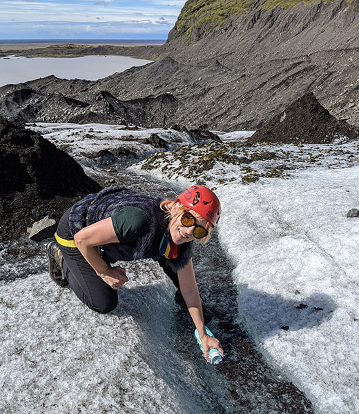 The author fills up a water bottle from a glacial stream before climbing the Falljokull glacier. | Photo courtesy of Jessica Fender