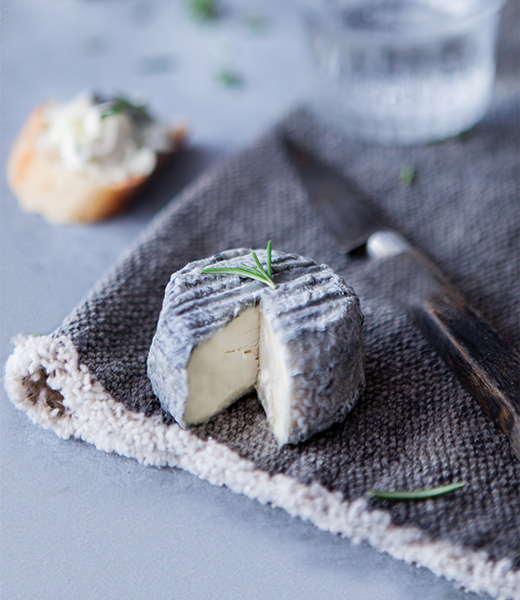 Goat cheese beside a cheese knife placed on a cloth napkin