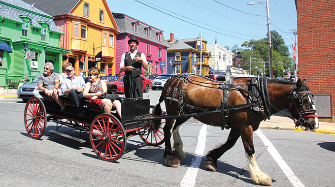 Visitors learn about Lunenburg’s rich history on land during a horse-drawn wagon tour of the seaport’s colorful streets. | Photo by Rick and Mimi Steadman