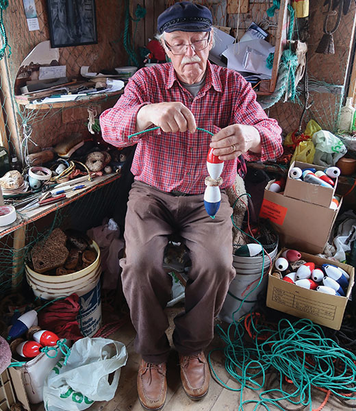 Fisherman Roger strings floats in his Buoy Shack. | Photo by Rick and Mimi Steadman