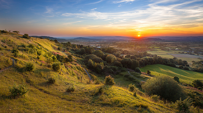 The sun sets over Cotswold hills. | Photo by Leigh Cousins / Alamy Stock Photo