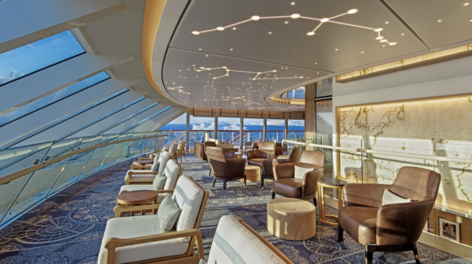 Cruise ship lounge with floor-to-ceiling windows.