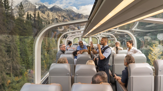 Travelers listening as a host speaks aboard the Rocky Mountaineer