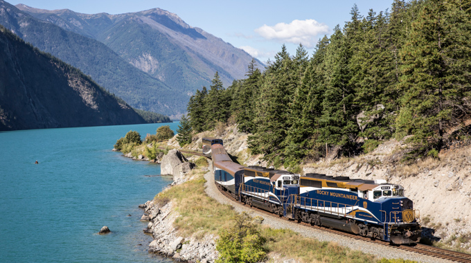 Rocky Mountaineer traveling alongside a lake