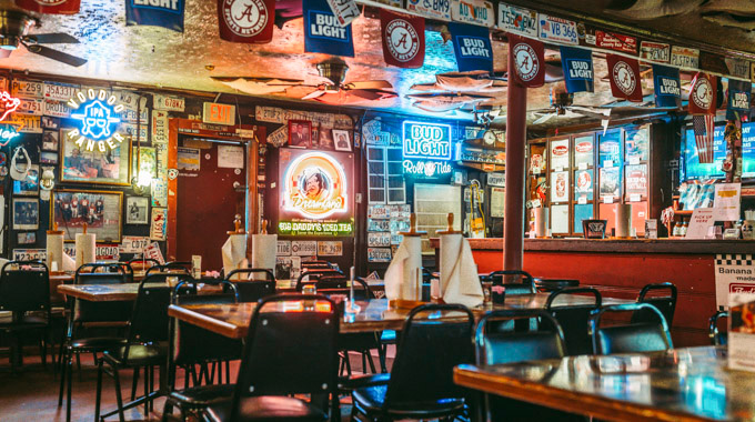 Signs, neon lights, and beer flags fill the walls at Archiblad & Woodrow's BBQ