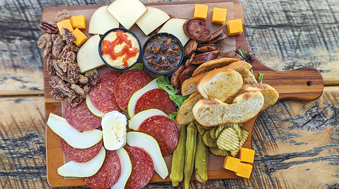 A wooden board loaded with food at Woody's Roadside
