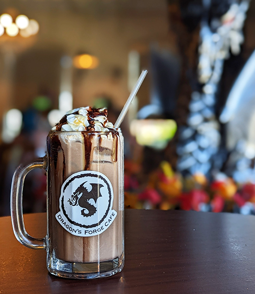 A drink topped with whipped cream and chocolate syrup at Dragon Forge Cafe