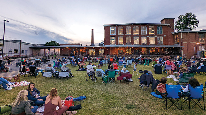 Crowds relaxing on the grass at Lowe Mill