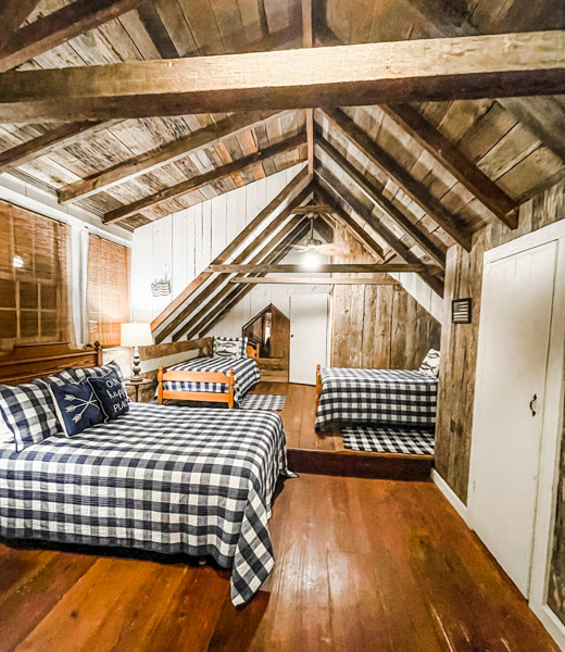 Beds with checkered linens inside the guest room at Blackberry Lane Farm