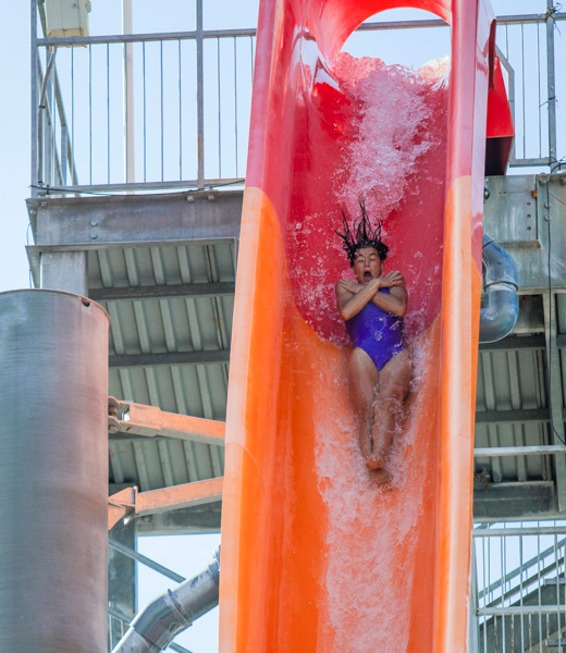 Girl gasping as she goes down a water slide