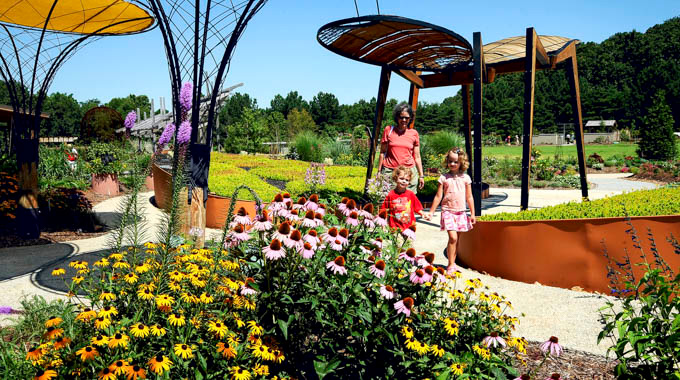 Woman and 2 children walking through the Sensory Garden