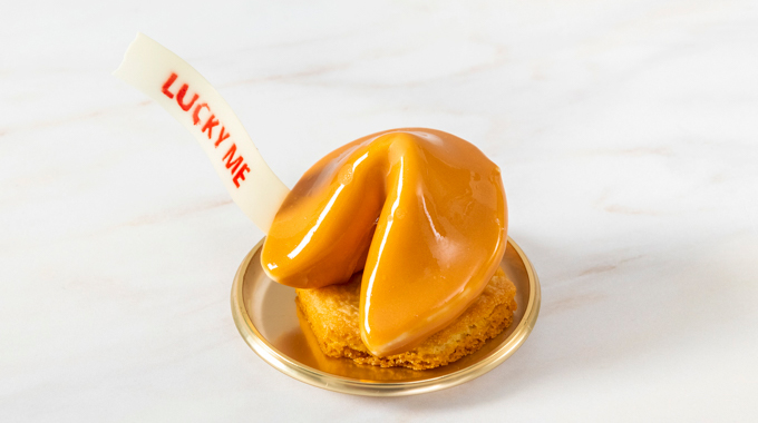 A pastry shaped like a fortune cookie, complete with an edible fortune reading "lucky me"