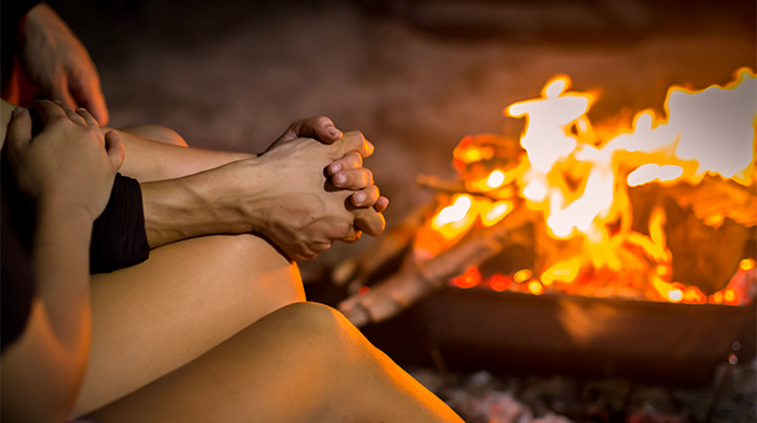 Sitting around a fire pit on the beach is a popular—and wallet-friendly—date-night idea. | Photo by Global Moments / stock.adobe.com