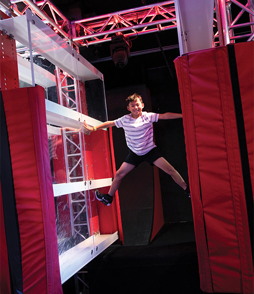 Boy climbing an obstacle at American Ninja Warrior Adventure Park