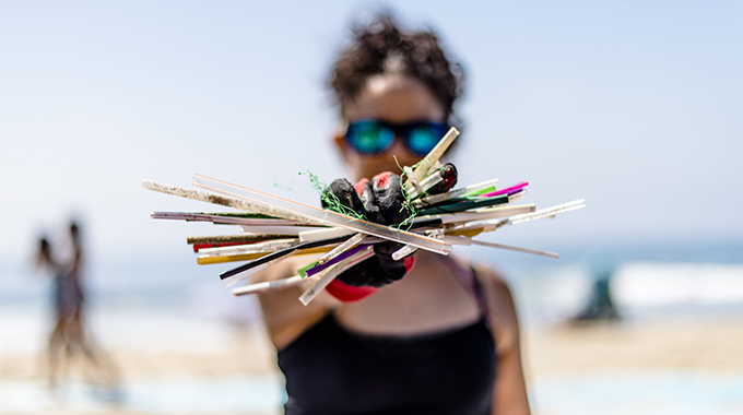 A volunteer holds up trash collected during a coastal cleanup