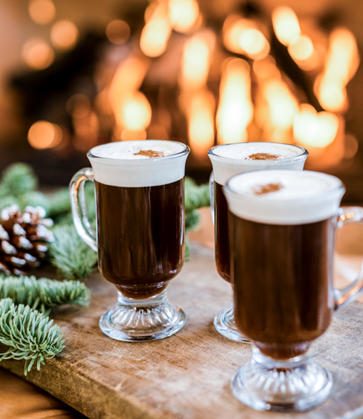 Three glasses of hot cocoa topped with whipped cream.