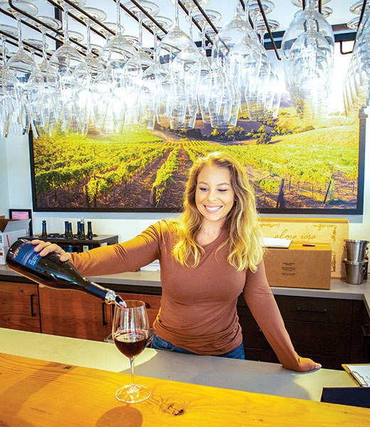 Woman pouring a glass of red at Alma Rosa Winery