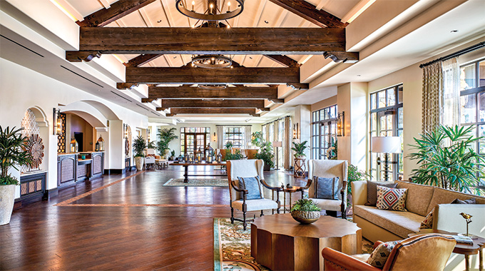 The Inn at Mission San Juan Capistrano lobby features exposed wooden beams, floors, and furniture 